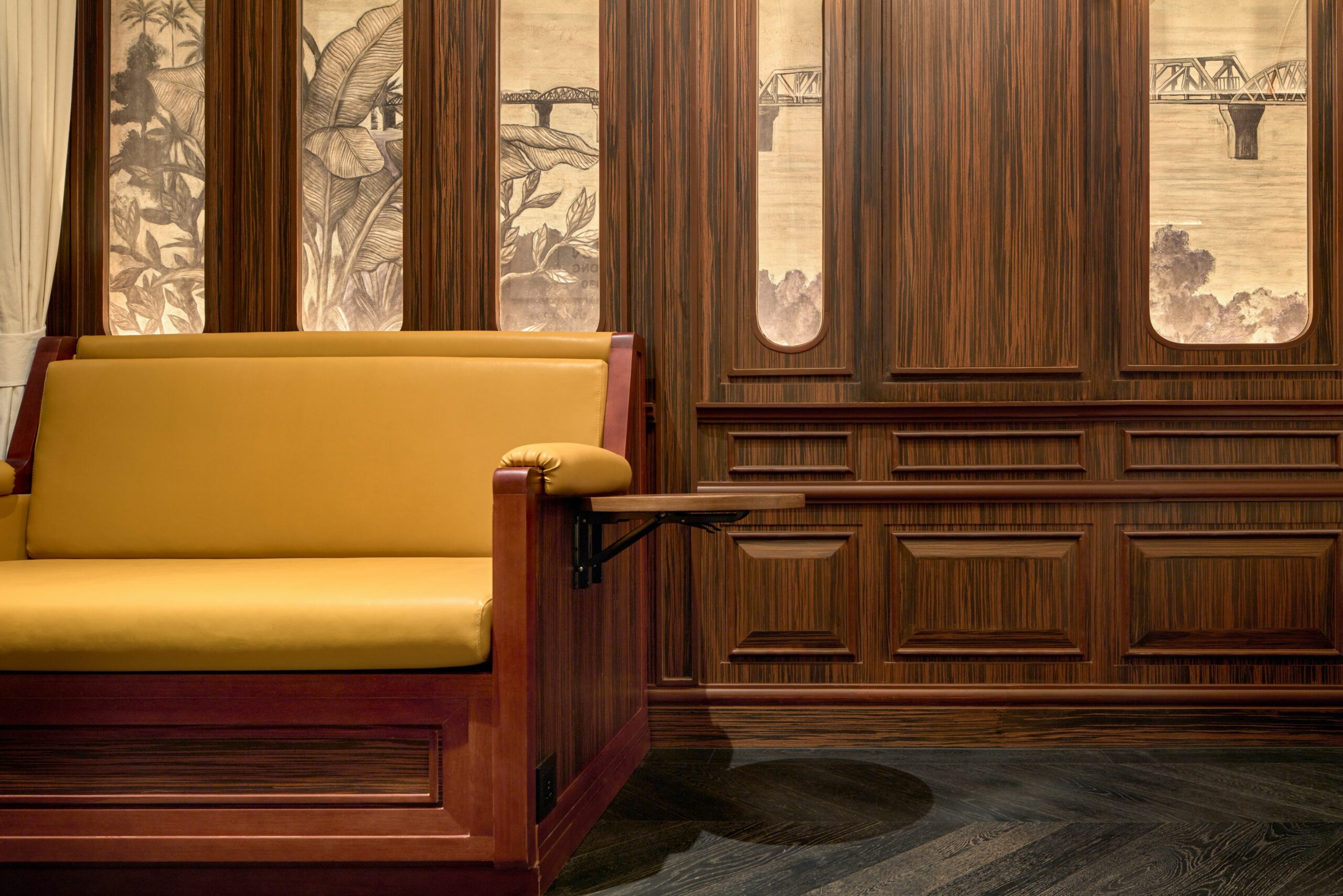 an interior shot with a yellow couch and brown wood paneling at intercontinental khao yai resort
