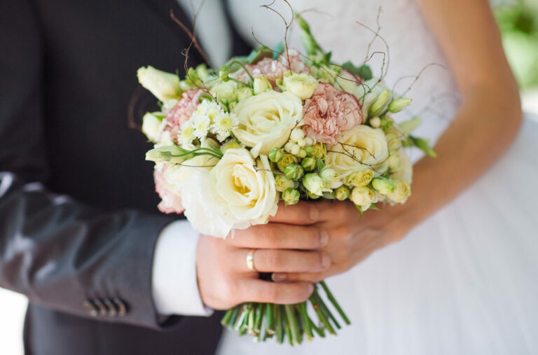 a bride and groom holding a bouquet together