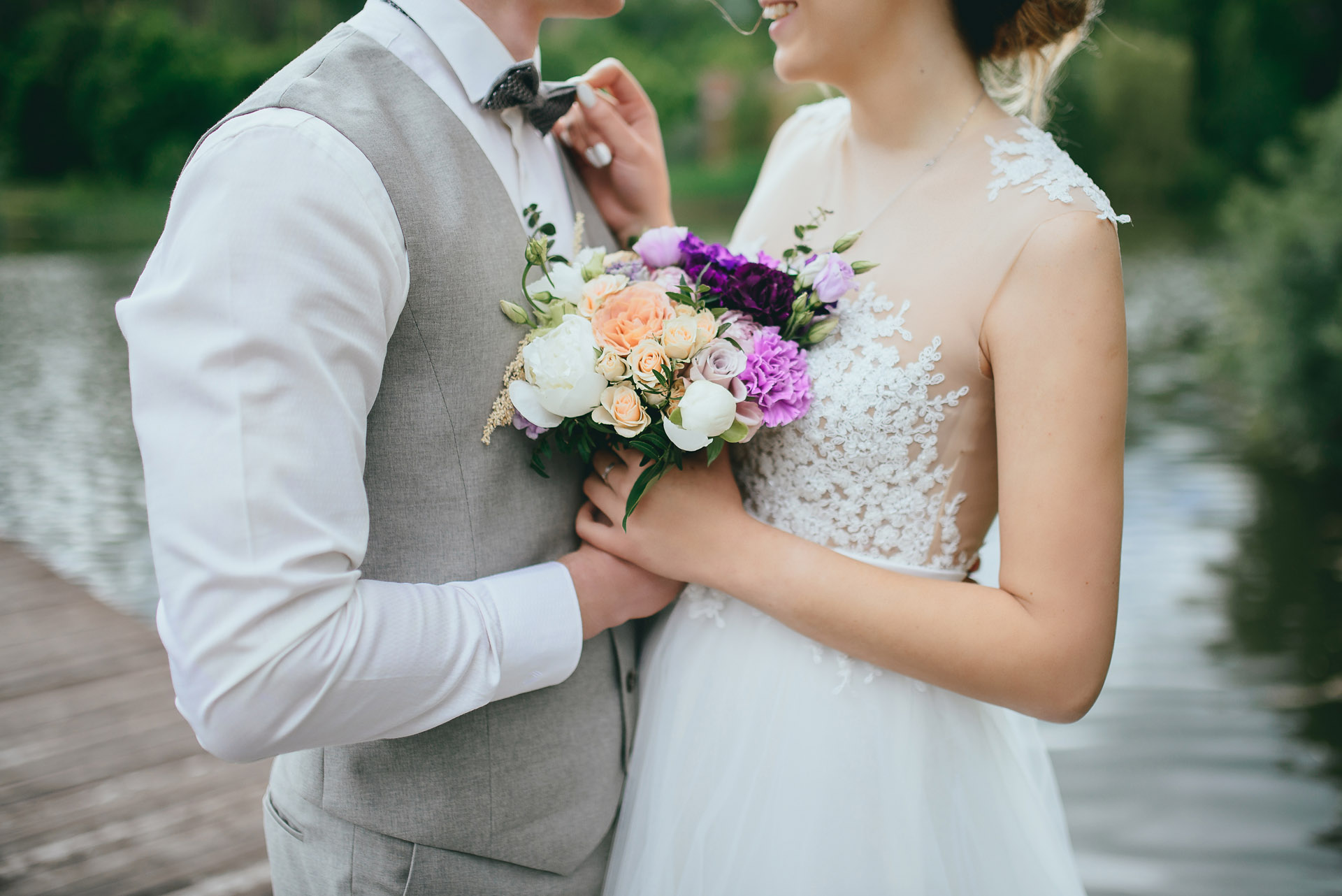 bride and groom holding a shared bouquet