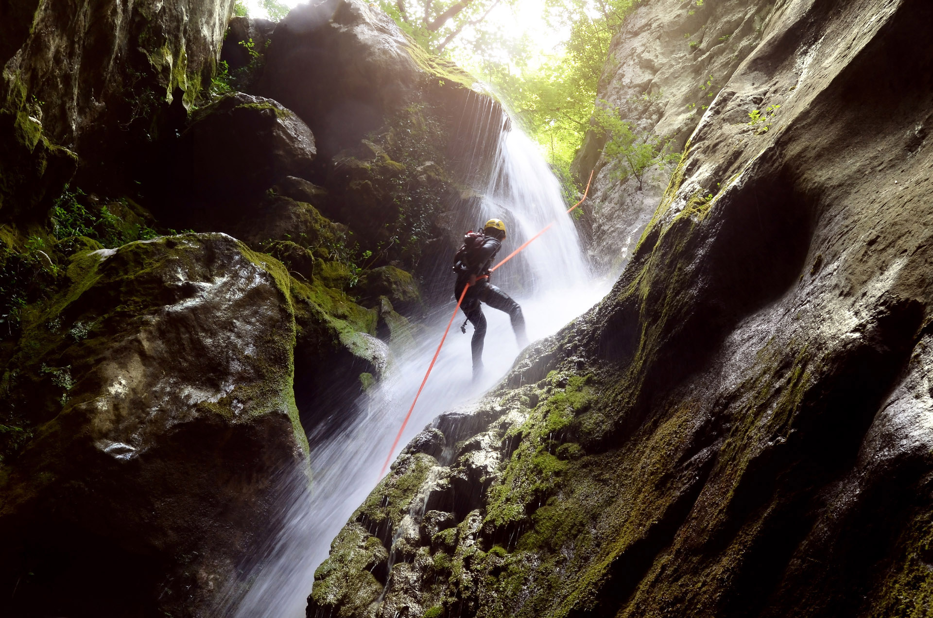 canyoning down an angled tropical waterfall