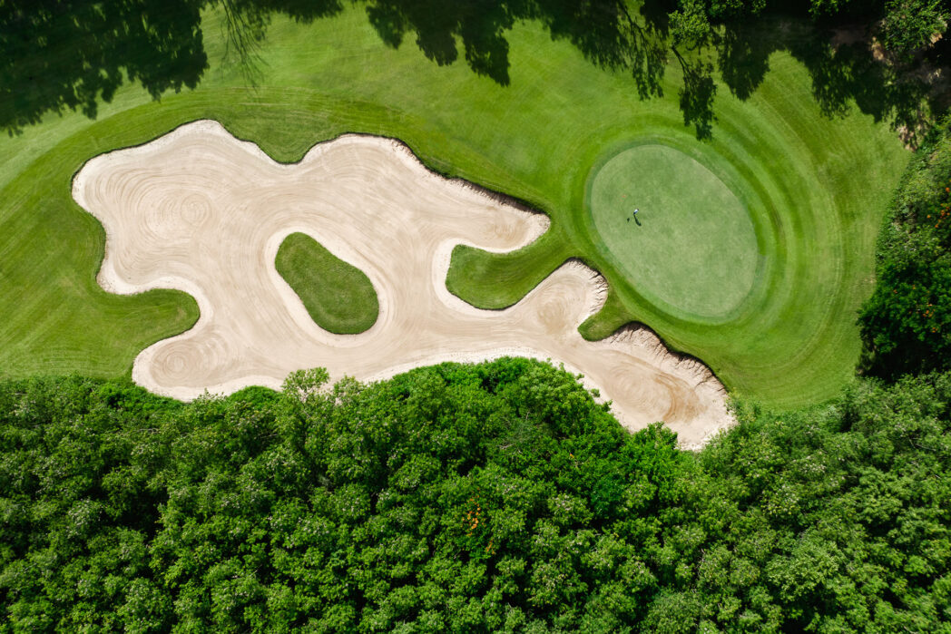 overhead view of golf course with sand trap and green