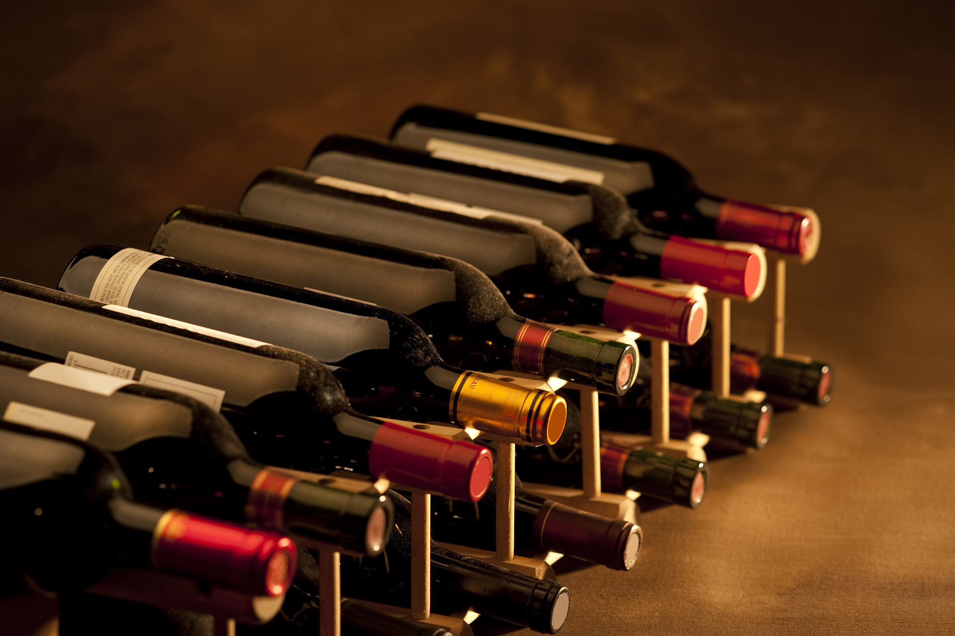 horizontal rack of dark wine bottles