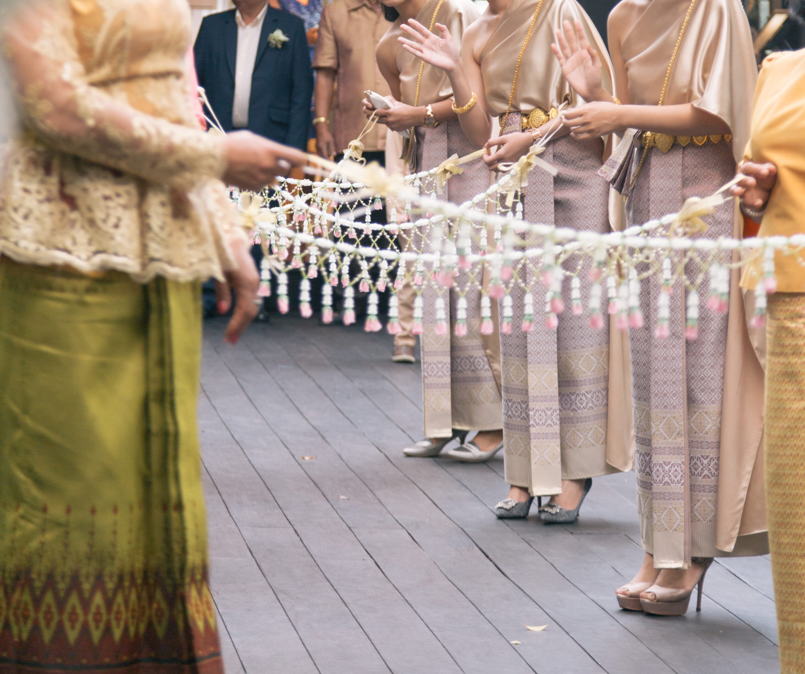 thai bridesmaids with long strings of jasmine garlands